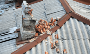 un tetto con una canna fumaria in amianto deteriorata