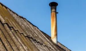 dettaglio di tetto e comignolo con tegole in eternit
